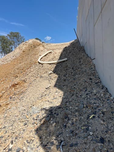 Retaining wall and earthworks area on the M12 Central project, used to illustrate the civil infrastructure environment where project management and completion-stage closeout support were required.