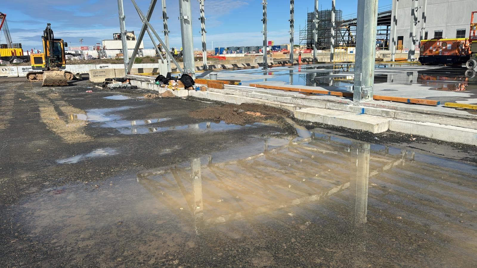 Civil project site with wet-weather ground conditions, plant equipment and structural work areas, supplied by Sagona Bros for an HSEQ and ISO certification case study.